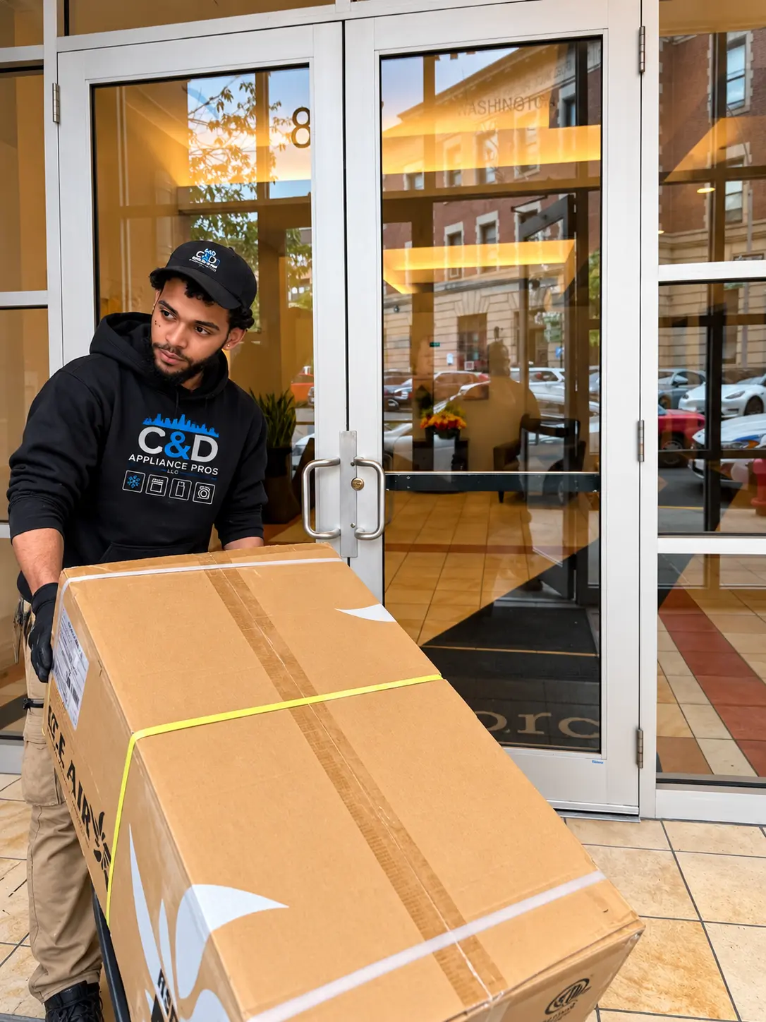 C&D Appliance Pros technician delivering a new appliance to a building entrance